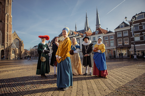 A group of six traditionally dressed male and female tourist guides in Delft on a spring day