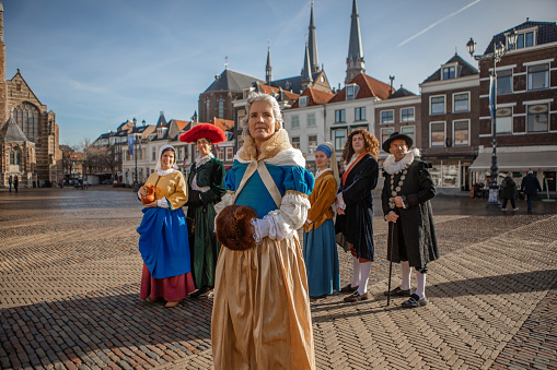 A group of seven traditionally dressed male and female tourist guides in Delft on a spring day