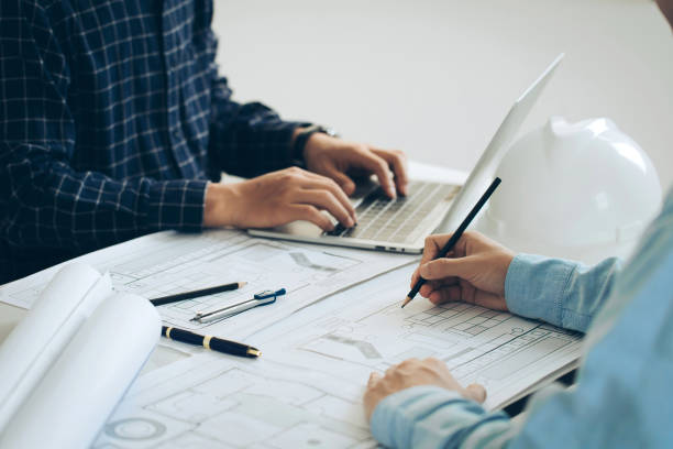 istock Architectural engineer team drawing on blueprint and meeting for project working with a partner on model building and engineering tools in working site. Planning.Construction, and structure concept. 1992322065