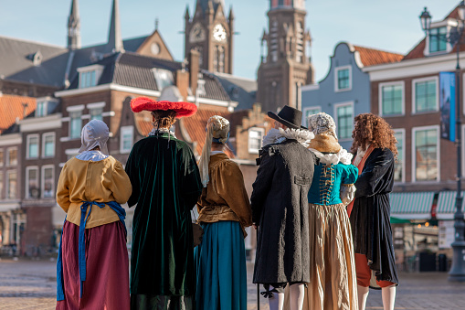 A group of six traditionally dressed male and female tourist guides in Delft on a spring day