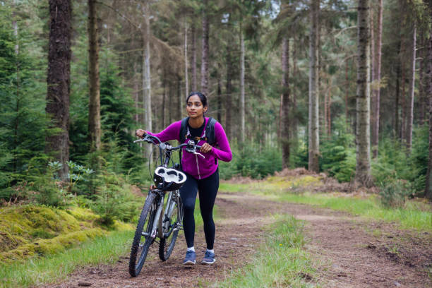 pchanie roweru pod górę - mental health women asian ethnicity bicycle zdjęcia i obrazy z banku zdjęć