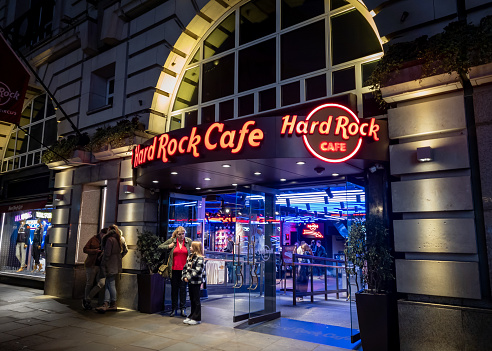 London. UK- 02.04.2024. A night time exterior view of the name sign, facade and entrance of the Hard Rock Cafe in the West End.