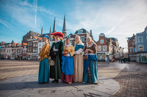 A group of traditionally dressed male and female tourist guides in Delft on a spring day