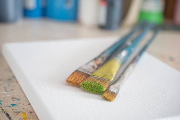 A collection of used paintbrushes in a jar, photographed in soft natural light with shallow depth of field. The image conveys a sense of creativity, artistic atmosphere, and daily life inside a working artist’s studio. Ideal for themes of inspiration, craftsmanship, and visual storytelling.