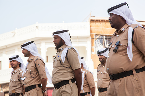 Doha, Qatar-December 16,2023 : Police in traditional dress on front of the police station in the market called \