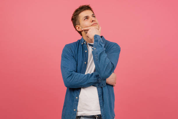 Portrait Thoughtful young man on pink background