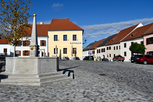 Stadtschlaining, Austria - November 07, 2023: The town's cobbled main square with town hall (Rathaus) and fountain situated in south Burgenland