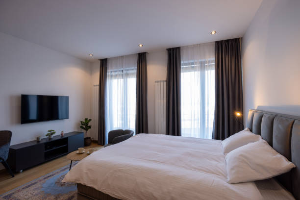 istock Interior of a bedroom with large master bed and wall mouted tv 1992408725