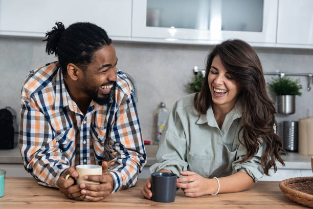 istock Simple living. Young couple drinking their first morning coffee in the kitchen discussing improving the quality of their love relationship, respect they have for each other and their plans for the day 1992414206