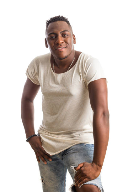 istock afro descendant man looking confident at camera. hand on knee. Standing against white background. 1992421719