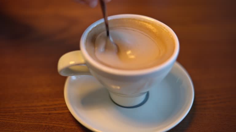 Woman hands stiring coffee foam