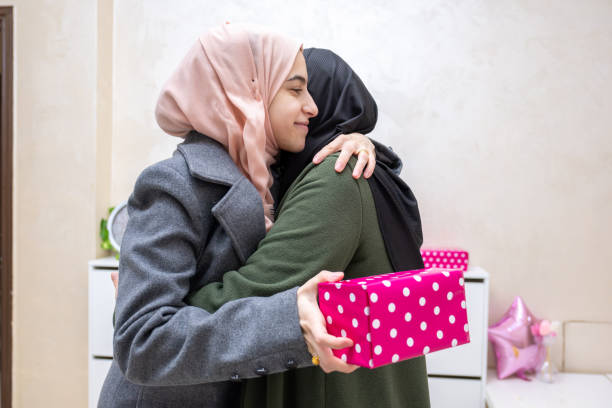 istock muslim Daughter hugging and gifting her mother 1992436295