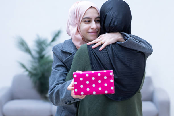 istock muslim Daughter hugging and gifting her mother 1992437216
