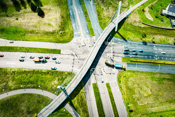 traffic at a junction with a winding bicycle path bridge seen from above - traffic sea passage overpass car ストックフォトと画像