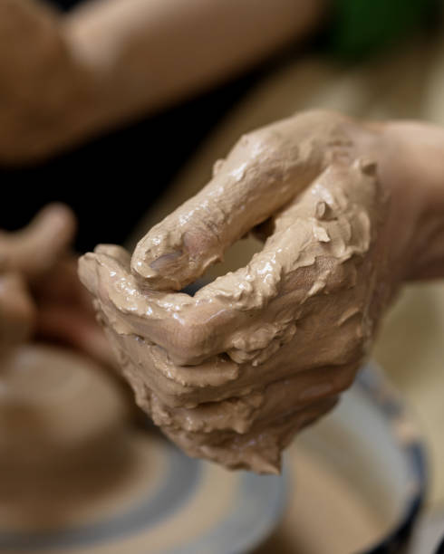 istock One woman's hand in clay after starting work on a potter's wheel. Close-up 1992457849