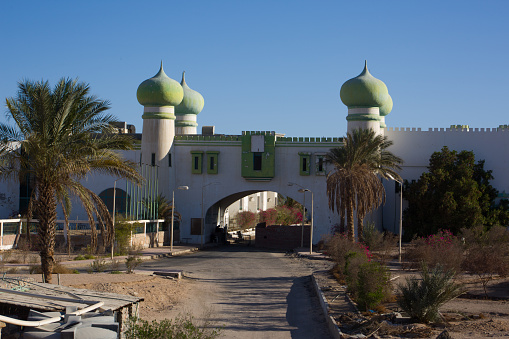 Entrance to abandoned hotel in the Egyptian desert in Arabic style with domed towers. Unfinished building in Africa