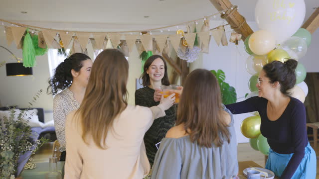 Group of women friends making a toast at a baby shower party