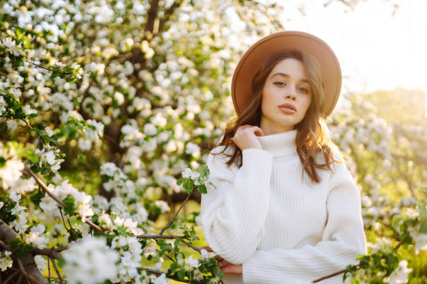 istock Young woman enjoying scent in blooming spring garden. 1992467437