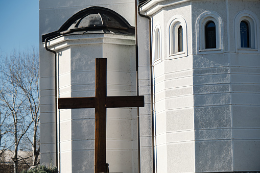 A large wooden cross on the background of white chapel. Church of St. Simeon is made in the Byzantine style. Belgrade, Serbia - Novi Beograd district