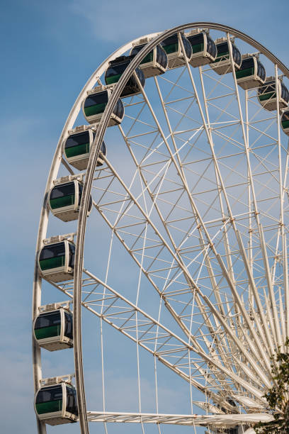 Close-up of a large Ferris wheel structure against the sky in Bangkok, symbolizing fun and leisure.