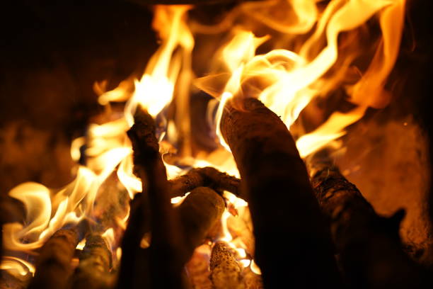Yellow bright bonfire on black background, horizontal view. Orange flame of campfire in night.