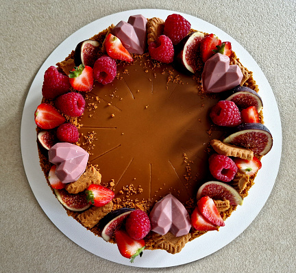 chocolate cake frosting. on the side to indicate the year of birth. sliced raspberries and strawberries. bavrchu in a circle. Parisian whipped cream. luxury, walnut, with nuts and figs with icing, lotus, making