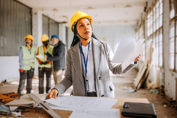 istock Female architect looking at the architectural project at the construction site 1992575558