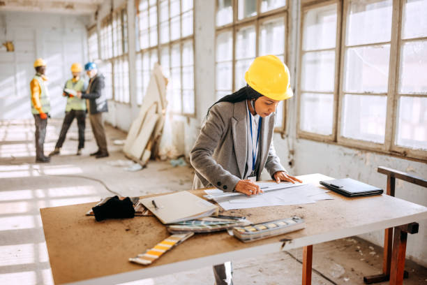 istock Female architect looking at the architectural project at the construction site 1992577765