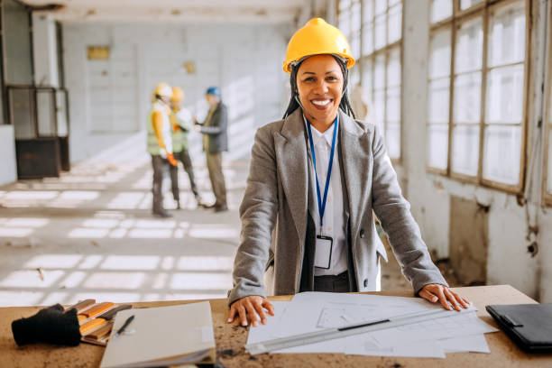 istock Female architect looking at the architectural project at the construction site 1992577804