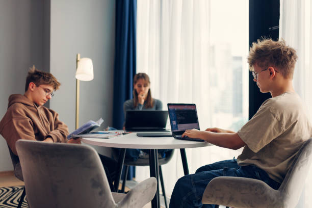 istock Teenagers using laptops and studying at home 1992582648
