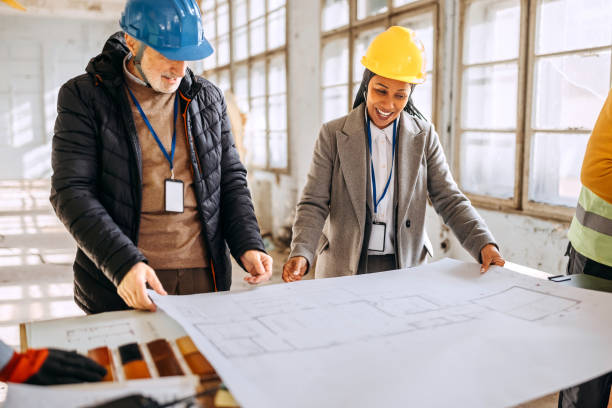istock Architects looking at the architectural project and explaining to construction worker what to do 1992584242