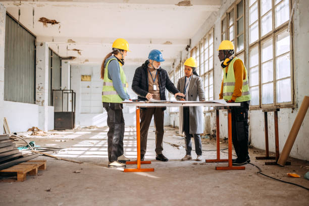 istock Architects looking at the architectural project and explaining to construction worker what to do 1992585303