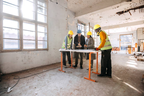 istock Architects looking at the architectural project and explaining to construction worker what to do 1992594290