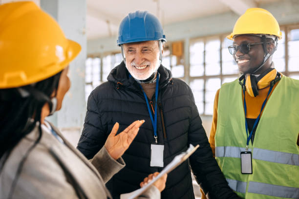 istock Architects looking at the architectural project and explaining to construction worker what to do 1992599108