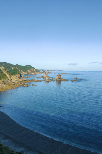 istock A scenic view of a rocky coastline, clear blue waters, and greenery under a bright sky 1992601185