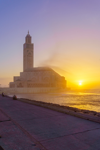 Sunset view of the Hassan II Mosque, with the promenade and El Hank Lighthouse, in Casablanca, Morocco