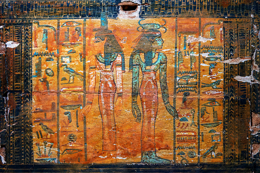 Antique egyptian hieroglyphs and paintings on an old colorful painted wood chest in the from the tomb of the ancient Egyptian artisan Sennedjem, Cairo museum, Egypt