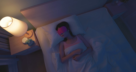 Top view asian woman wearing sleep mask at night