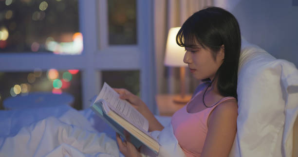 istock asian woman read book bedtime 1992619638