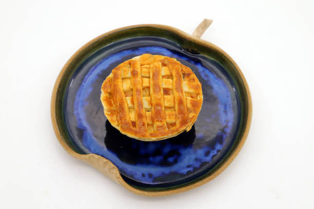 A delicious pie resting on a plate atop a white background.