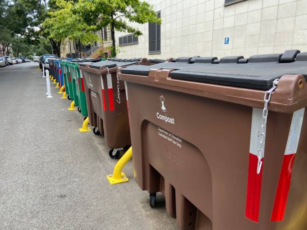 Curbside trash containers outside of a pubic school on 152nd Street in West Harlem, New York City New York, NY USA - August 18, 2023 : Two large brown curbside trash containers with the word "Compost" and "Department of Education Custodial Staff Use Only" in a row of colorful bins outside of a pubic school on 152nd Street in West Harlem, New York City harlem park stock pictures, royalty-free photos & images