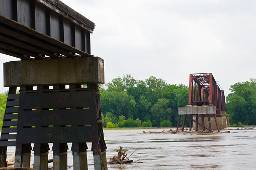 Contrasting Bridges: A modern, sturdy concrete and steel structure meets a rusted relic of the past. This tranquil riverside scene captures the intersection of progress and nostalgia in Evansville, Indiana.