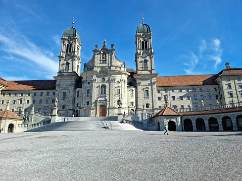 The Abbey of Einsiedeln is one of the most important baroque monastic sites and the largest place of pilgrimage in Switzerland. The image shows the building exterior with the two towers and the main entrance.