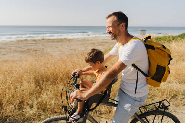 istock Young boy's riding on a bicycle with his dad 1992705133