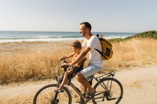 istock Young boy's riding on a bicycle with his dad 1992705142