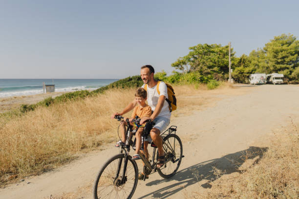 istock Young boy's riding on a bicycle with his dad 1992705144