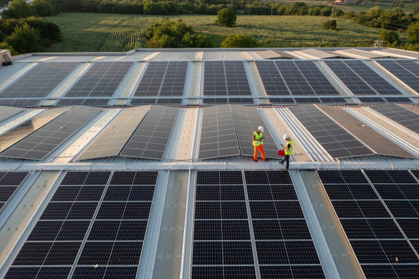 istock Aerial view of workers installing solar panels on a roof. 1992724420