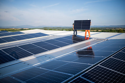 Teamwork is dreamwork, they installing solar panels on industrial roof.