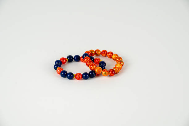 istock Two bead bracelets in orange and black on white background 1992738248