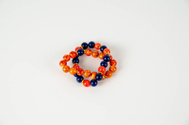 istock Two bead bracelets in orange and black on white background 1992738765